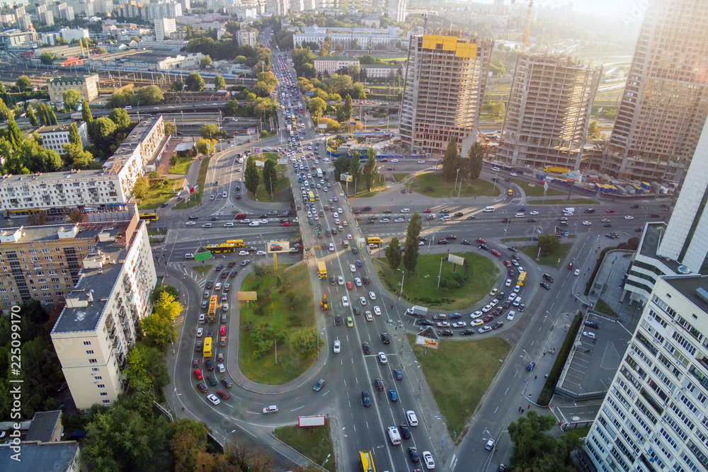 Fototapeta premium Aerial drone view of two level road junction during rush hour. Traffic jam in busy urban highway with circles. Busy street with lot of cars at Kiev, capital of Ukraine. Sunset golden hour flare