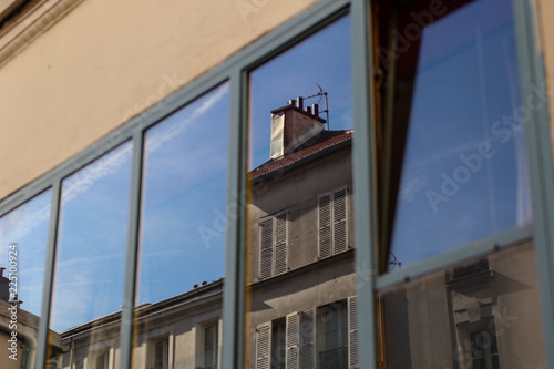 Immeuble parisien reflété dans une fenêtre