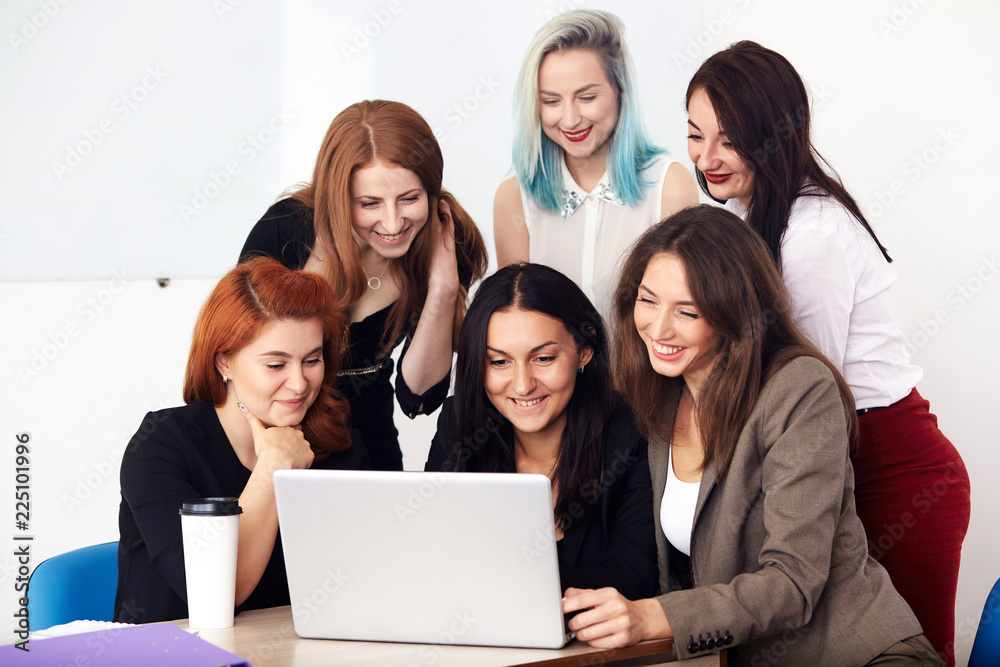Young smiling business women working new project at office.Coworkers team at business meeting looking in laptop on table.Analyze business documents,conference,discussion. Corporate concept. Young smiling business women working new project at office.Coworkers team at business meeting looking in laptop on table.Analyze business documents,conference,discussion. Corporate concept.