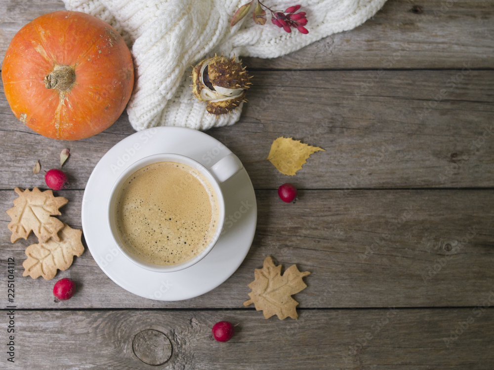 Coffee cup, knitted scarf, dry leaves, cookies, hawthorn and barberry fruits on a wooden background. Concept cozy atmosphere with a cup of coffee. Copy space, flat lay Coffee cup, knitted scarf, dry leaves, cookies, hawthorn and barberry fruits on a wooden background. Concept cozy atmosphere with a cup of coffee. Copy space, flat lay