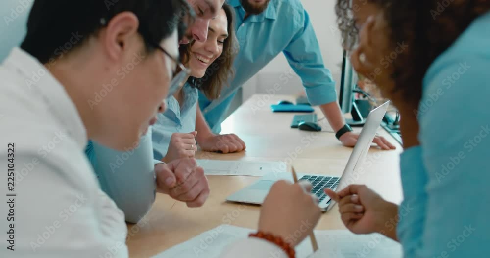 Large multi racial team of office workers communicating together and discussing a project on a computer screen. 4K UHD 60 FPS SLOW MOTION