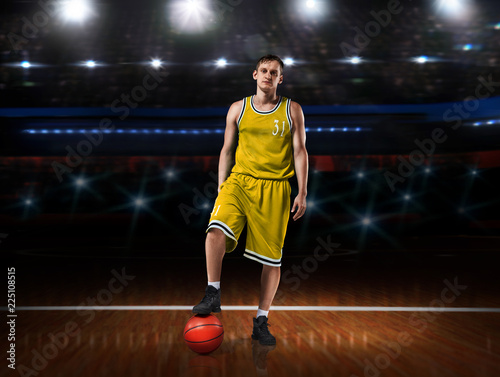 basketball player in yellow uniform standing on basketball court