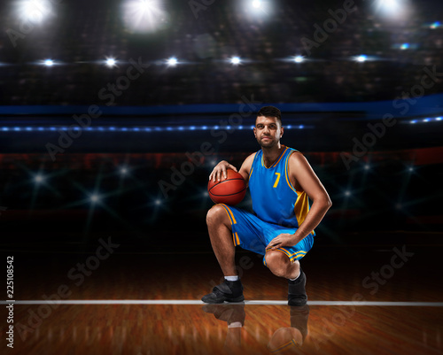 basketball player in blue uniform sitting on basketball court