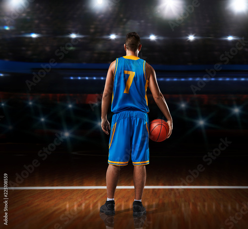 basketball player in blue uniform standing on basketball court