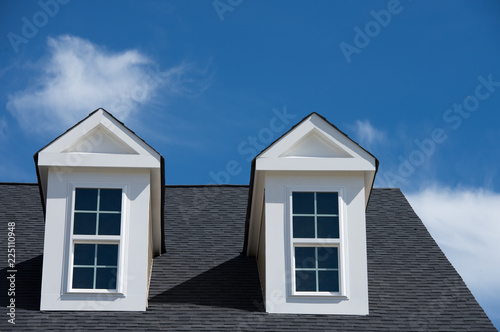 typical American house  with dormer window with a gable roof blue cloudy sky background on a new construction in Maryland photo