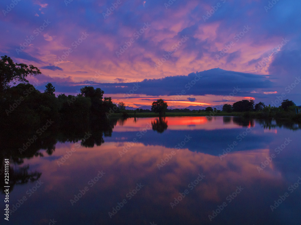 After heavy rain, sunset colours reflect in a a lake near Trat, Thailand.