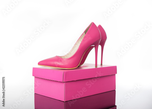 Double pink pointed high heels women's shoe and box on reflective floor