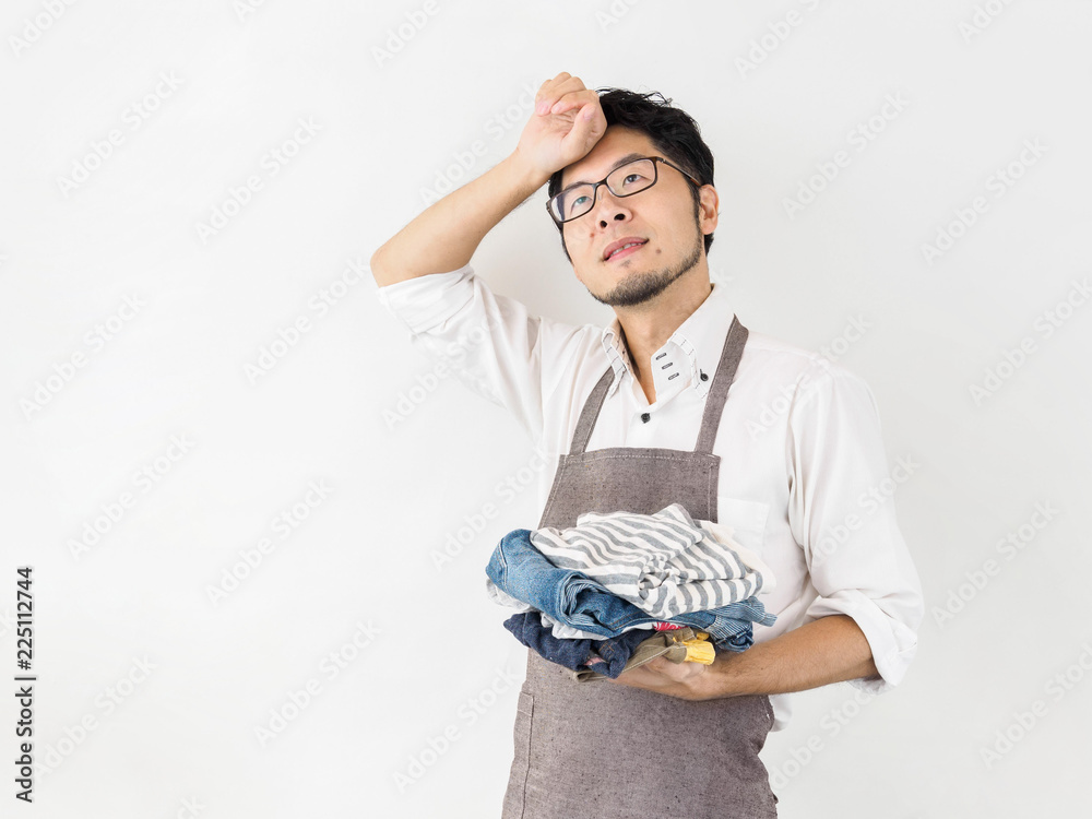 白背景の自宅にて洗濯物を取り込む日本人男性