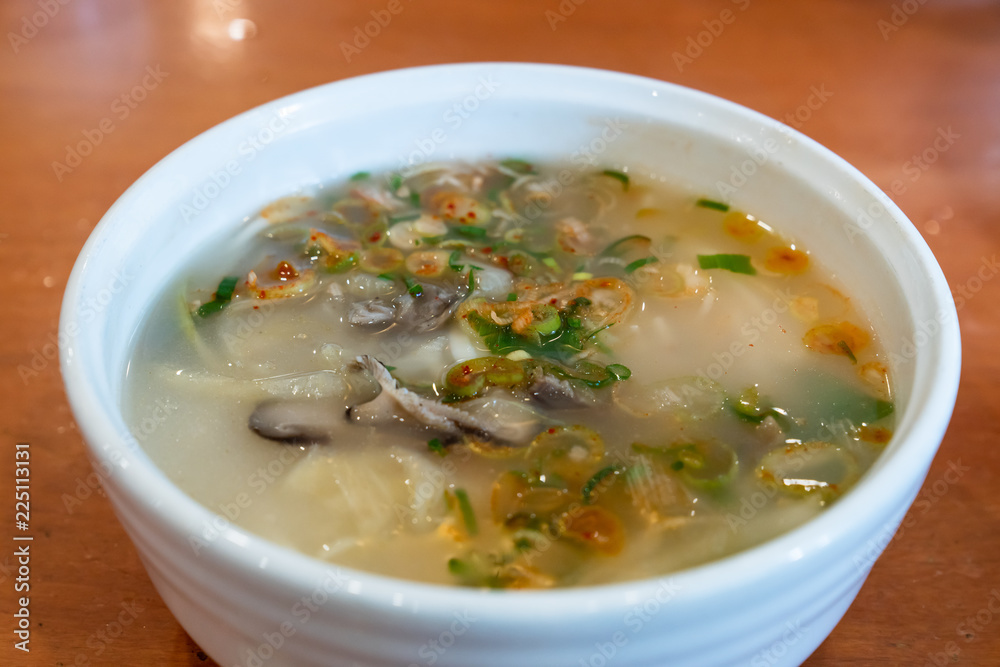 Korean dumpling soup with garnish such as fried eggs, Welsh onion, dried laver.