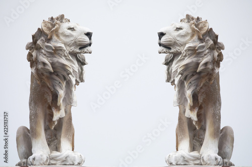 double twin Ancient Sculpture of White sitting Coade stone Lion isolated on white backgrounds, clad strong statue, leadership symbol monument photo