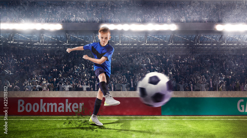 football player kid kicking the ball on the stadium