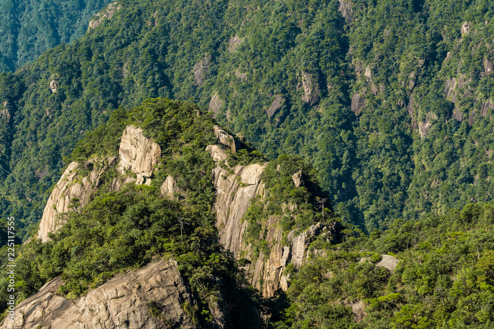 small peak with unique rock formation covered with forest at the valley of mount sanqing geo park