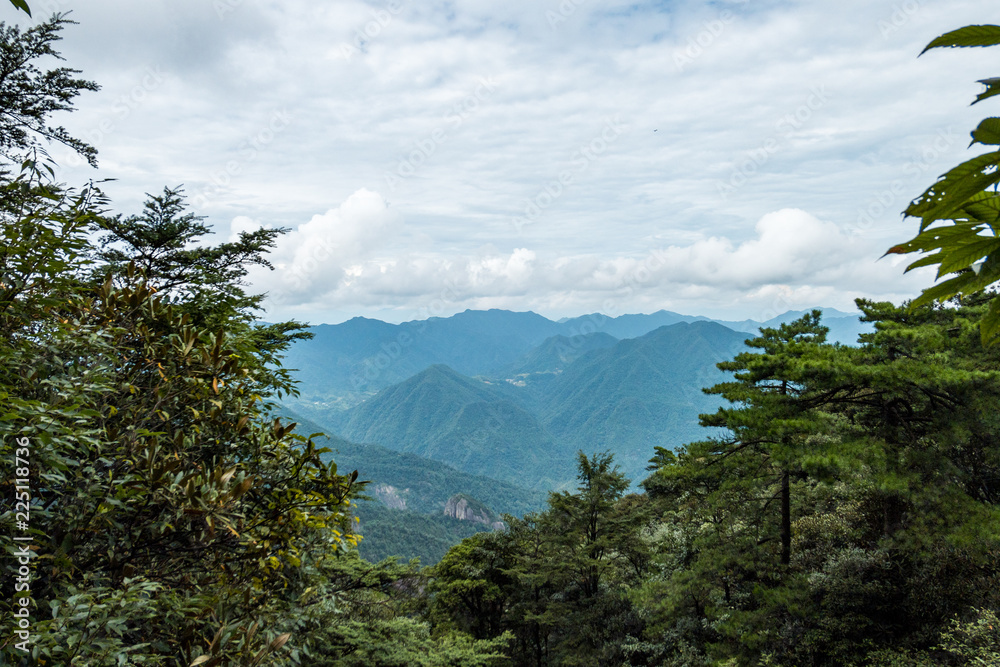 view of mount sanqing range under blue haze over the forest on the top
