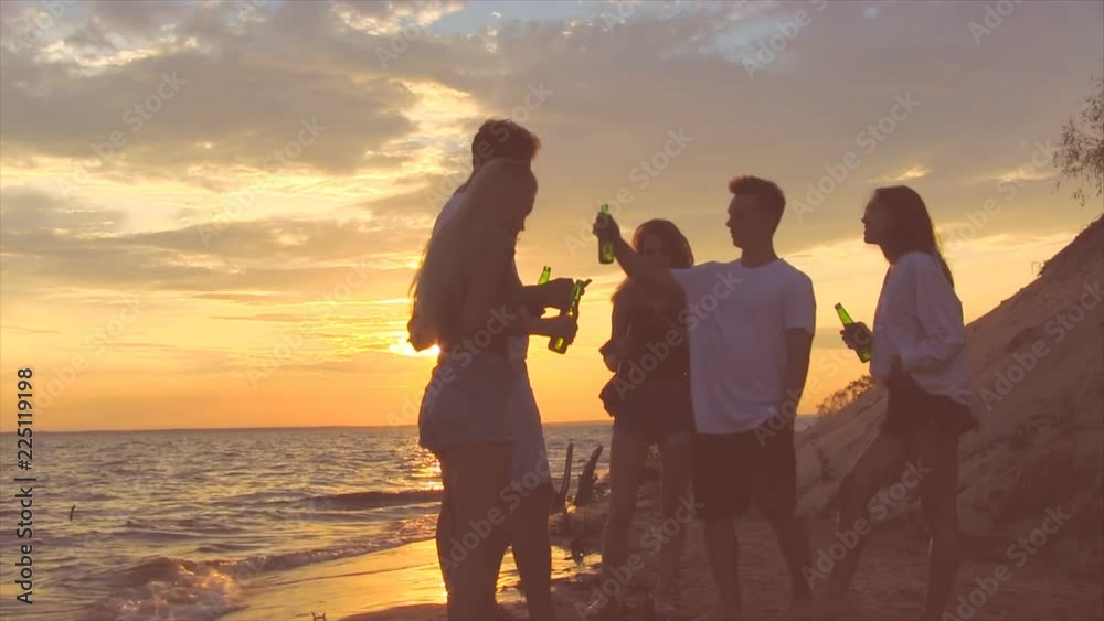 Friends near sea at sunset. Group of people enjoing good time. Friends near sea at sunset. Group of people enjoing good time.