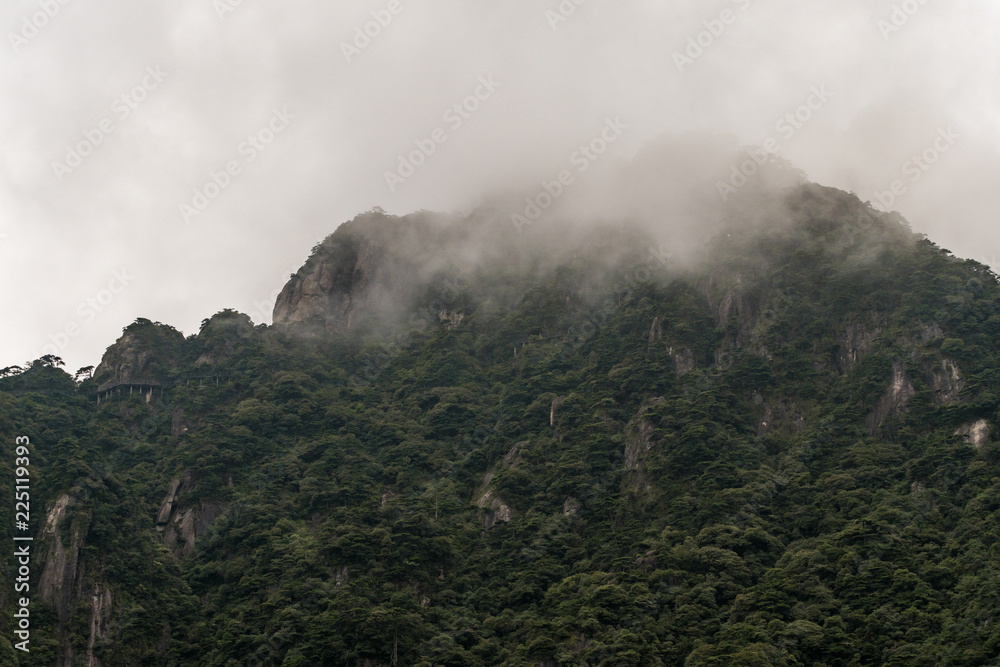 green covered mountain peaks under the thick mist