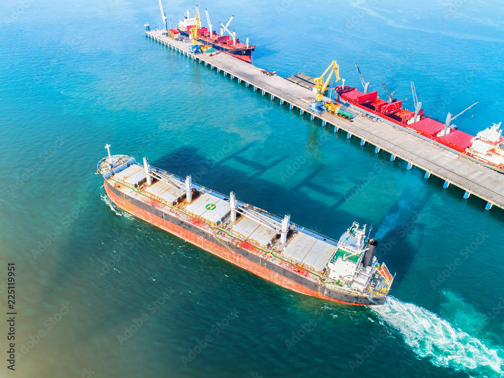 aerial view of the bulk general cargo ship on sailing departure from the sea port terminal