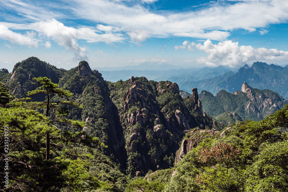 view of the valley of Mount SanQiang covered in forest under the blue cloudy sky