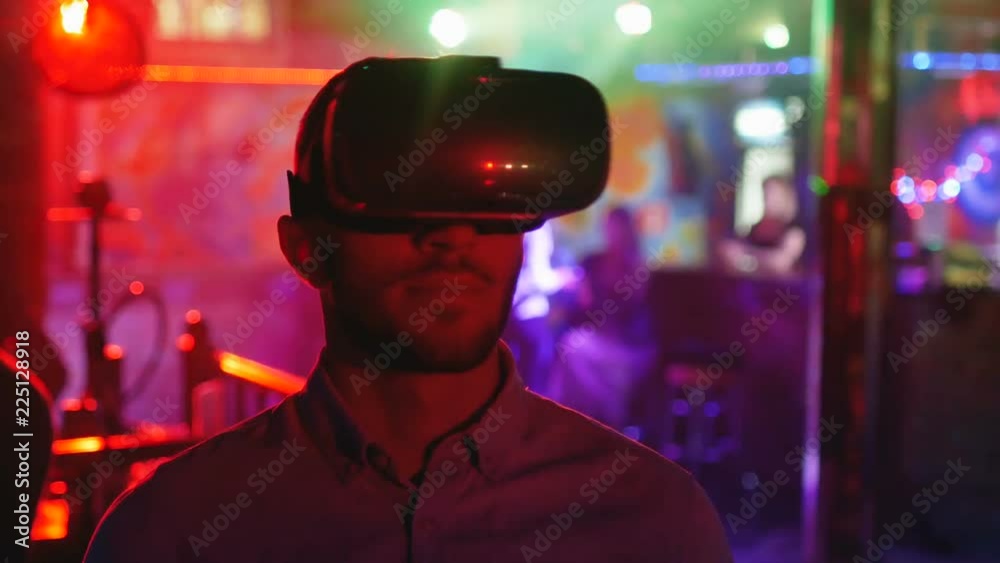 Young man in vr headset looks around, virtual reality, head-mounted display Young man in vr headset looks around, virtual reality, head-mounted display