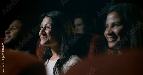 Young, diverse movie theatre audience enjoying a movie at the cinema.