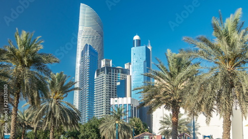 Corniche boulevard beach park along the coastline in Abu Dhabi timelapse with skyscrapers on background.