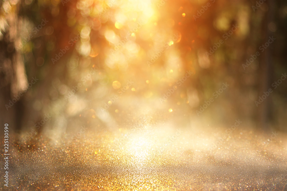 blurred abstract photo of light burst among trees and glitter golden bokeh lights. - obrazy, fototapety, plakaty 