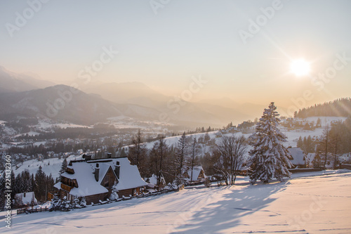 Traditional wooden house in the sunset background of the winter mountains in the ski resort of Zakopane, Poland