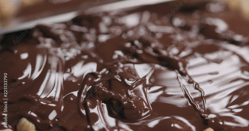 closeup spreading chocolate over roasted cashew closeup spreading chocolate over roasted cashew