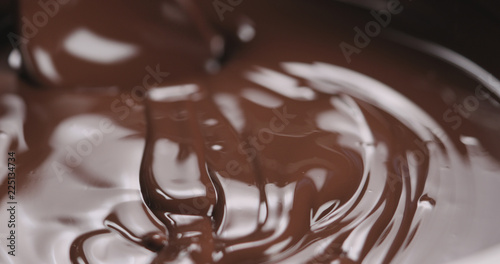 closeup stirring molten dark chocolate with spoon