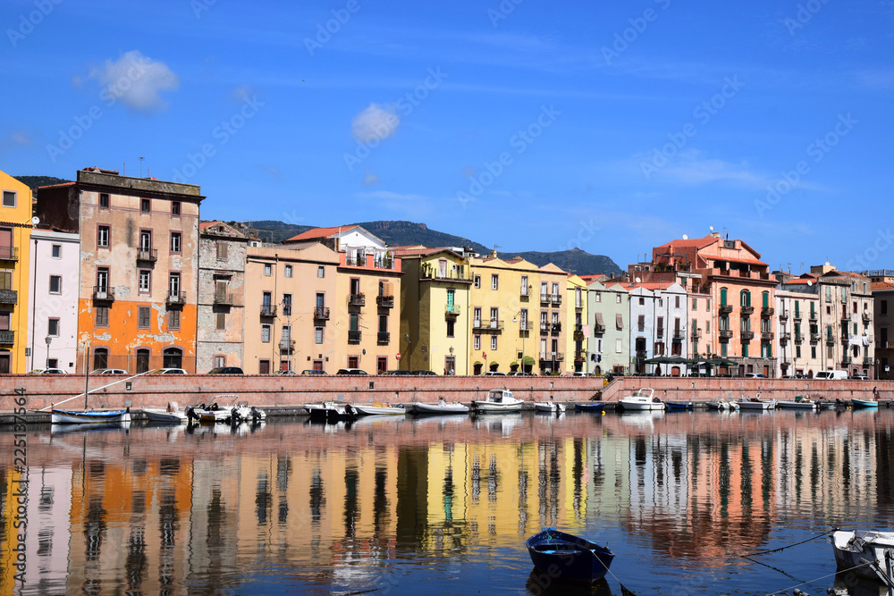 panoramic view on the boats on the river temo in Bosa in Sardinia including typical colorful Italian houses these are reflected in the river, idyllic river landscape in italy