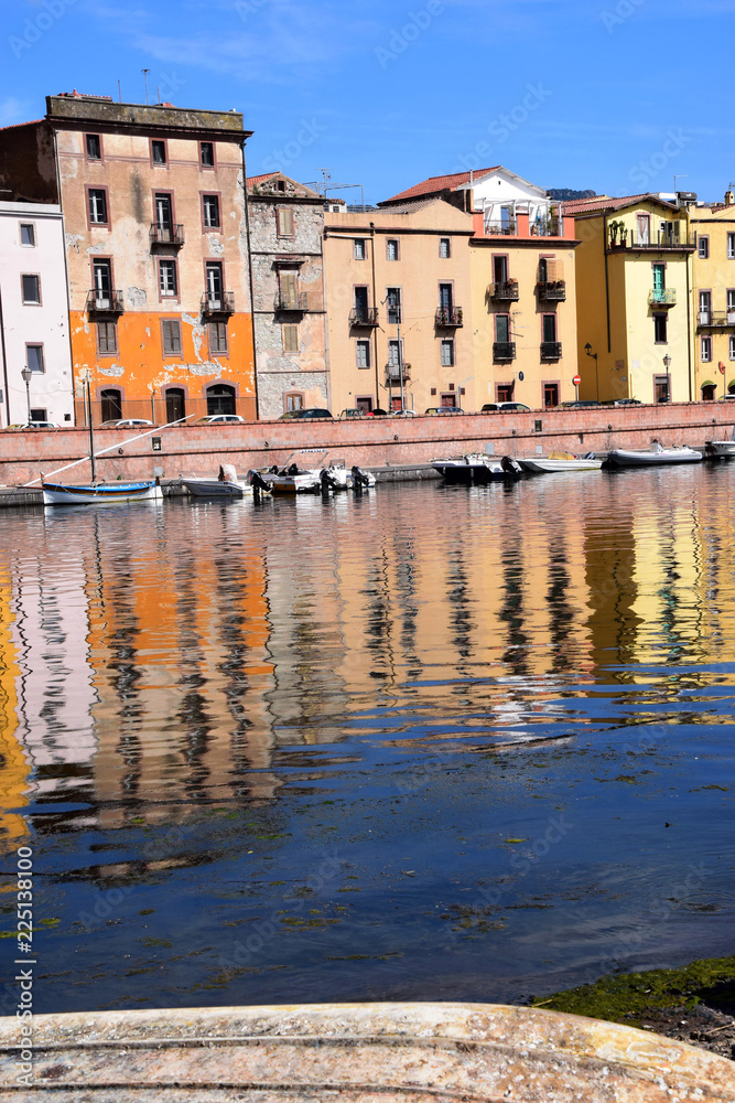 house and boat reflections in the river surface, panoramic view on the boats on the river temo in Bosa in Sardinia including typical colorful Italian houses these are reflected in the river
