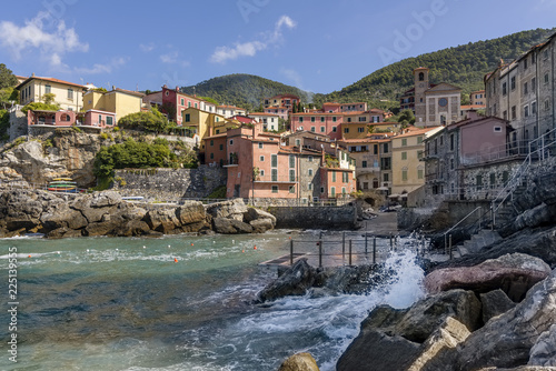 Beautiful view of the seaside village of Tellaro on a sunny day, La Spezia, Liguria, Italy, with the waves crashing on the rocks