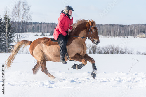 Woman on a galloping horse during winter. © Jani