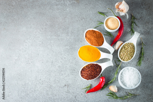 Spices in Wooden spoon. Herbs. Curry, Saffron, turmeric, rosemary, cinnamon, garlic, pepper, anise on wooden rustic background. Collection of spices and herbs. Salt, paprika. Copy space. © jeny_lk