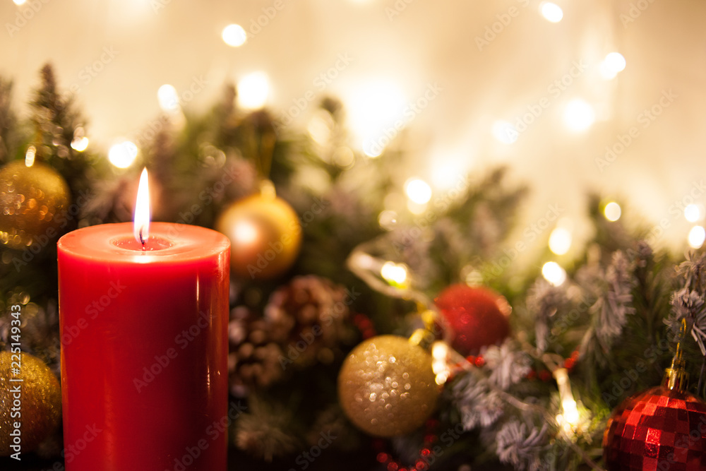 Fototapeta Christmas candles on the background of branches of a Christmas tree and glowing garlands