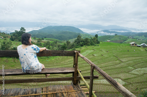 The pretty woman relaxing in holiday at rice terrace, Rice planting season in Chiang Mai, Tourism concept