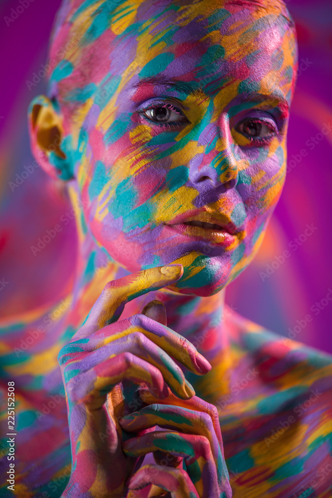 Portrait of the bright beautiful girl with brush, art colorful make-up face art and bodyart