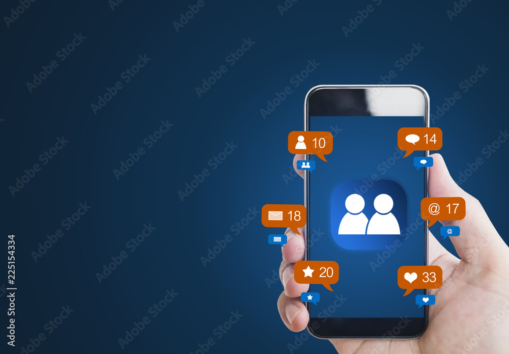 Hand holding mobile smart phone, with notification icons and online community icon on screen