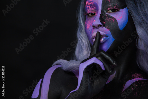 Portrait of beautiful girl, art make-up face art and bodyart on dark background. Halloween concept