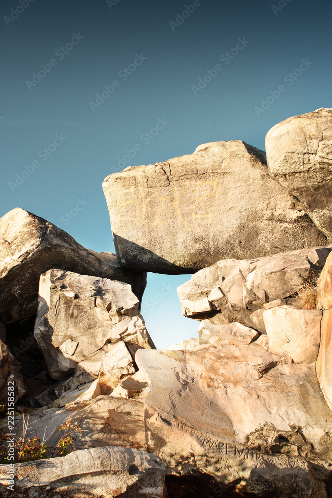 Detail of rocks and stones with a hole to see through the blue sky. Sandstone rock formation Teufelsmauer (Devil's Wall) in Blankenburg, National park Harz in Germany, Harz Mountains.