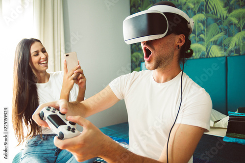 Virtual reality and wearable tech concept with young couple having fun together with headset goggles photo