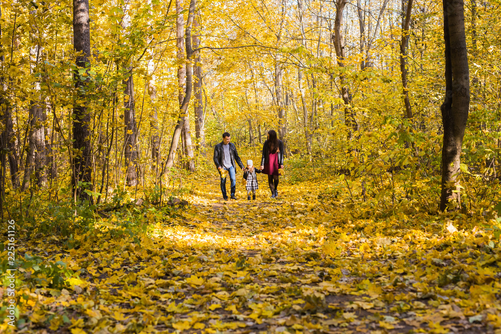 Fototapeta premium Fall, nature and family concept - happy family walking in autumn park