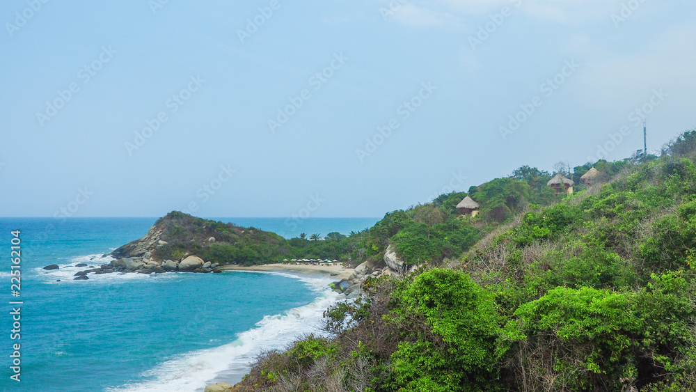 huts in front of a tropical beach with turquoise water at tayrona natural park