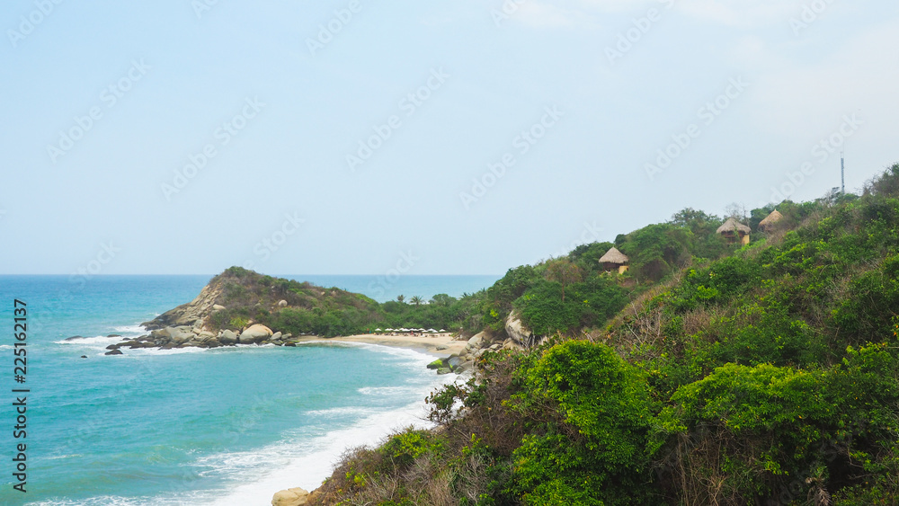 huts in front of a tropical beach with turquoise water at tayrona natural park