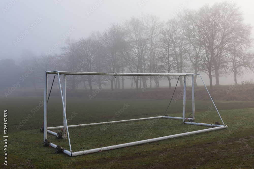 Football goalposts in a foggy field