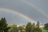 Bright double rainbow on the sky background.