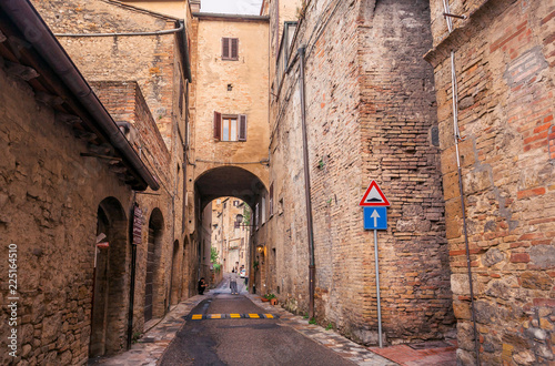 Narrow street between brick houses of the ancient town of Tuscany