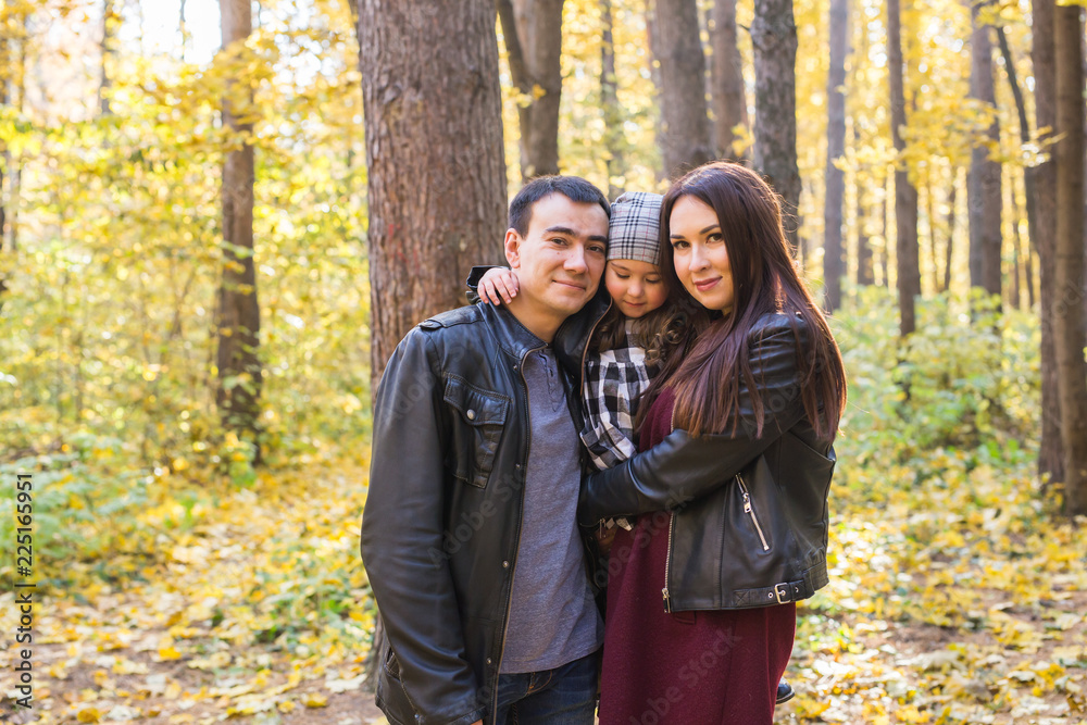 Fall, nature and family concept - happy family walking in autumn park