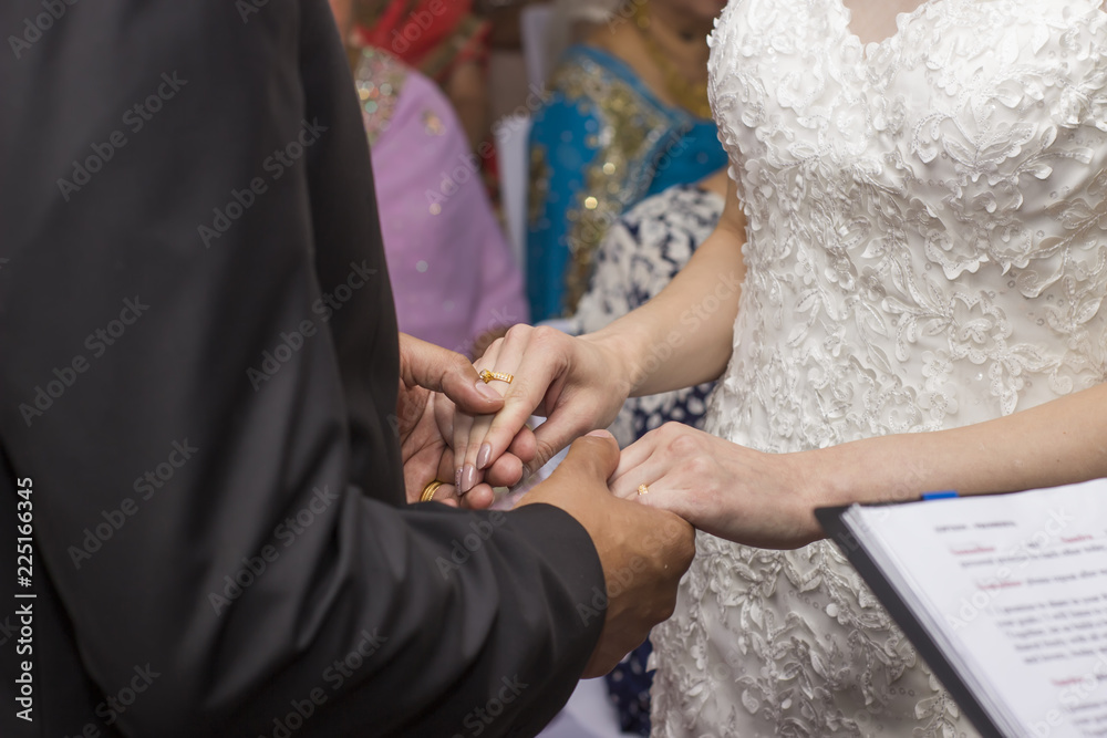 Fototapeta premium Groom and bride holding hands at wedding ceremony