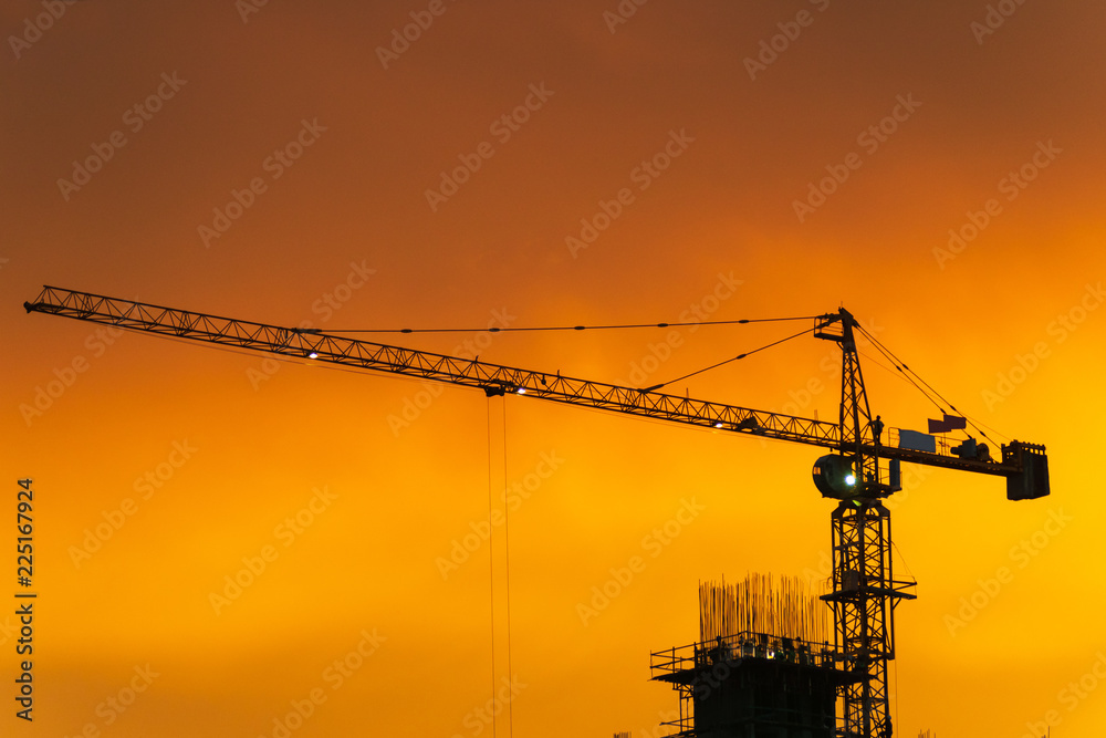 Silhouette crane in construction site at sunset