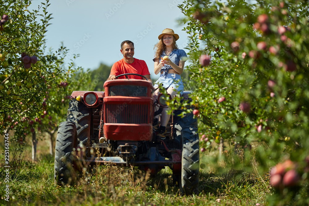Fototapeta premium Farmers couple driving tractor